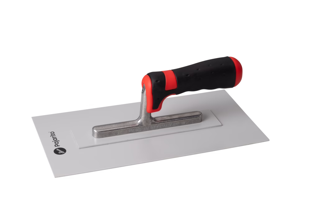 Une truelle en métal avec un manche ergonomique noir et rouge, reposant sur une surface rectangulaire plate. La lame est brillante et en acier inoxydable, et le manche a une prise texturée pour une manipulation facile. Le logo de la marque est visible sur la surface sous la truelle.