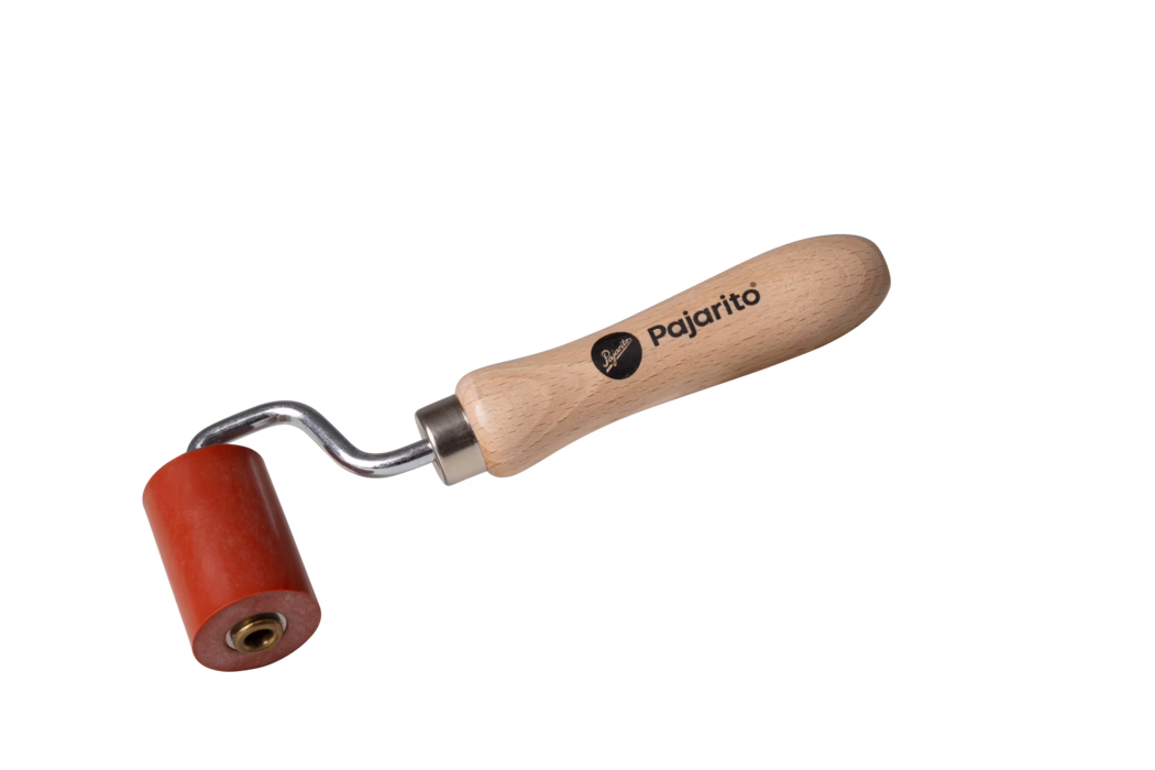Un petit rouleau de peinture robuste avec une tête de rouleau rouge et un manche en bois. Le manche est gravé du nom de la marque 'Pajarito'. Il est conçu pour une prise en main facile et pour l'application de peinture sur diverses surfaces.