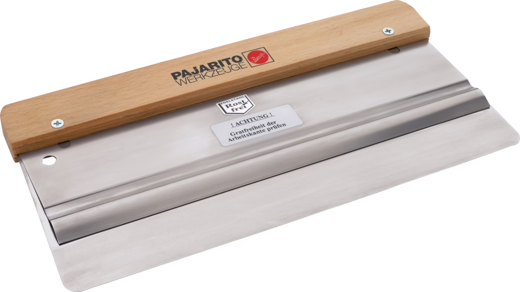 Large stainless-steel plastering/taping knife with a wide, flat polished blade and a light wooden handle. The rust-resistant metal blade features a straight working edge with rounded corners, a shallow central rib for stiffness and a small round hanging hole near one end. The wooden handle is fixed with two screws and printed with the black brand text 'PAJARITO WERKZEUGE' and a small red emblem; a manufacturer label on the blade reads 'EDELSTAHL Rostfrei' and a caution sticker in German warns to check the working edge for burrs. The tool is photographed on a neutral white background at a slight diagonal angle, highlighting the smooth reflective surface, clean edges and solid construction, intended for smoothing plaster, adhesives or filler.