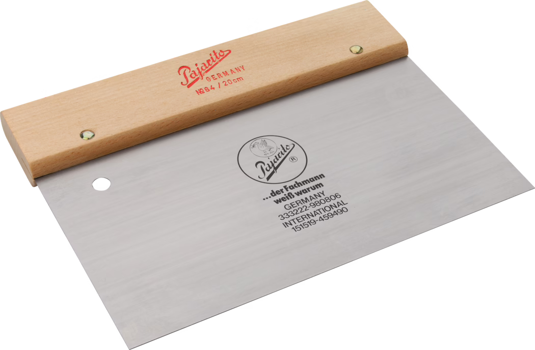 Pajarito_Dummy_Door spatula_034388_034395_2021-02 Un grattoir professionnel de haute qualité avec une poignée en bois. La lame est en acier inoxydable durable, marquée du nom de la marque 'Pajotits' et de l'origine du pays, l'Allemagne. Le grattoir est conçu pour un travail de précision, avec un bord plat pour lisser ou gratter les surfaces. C'est un outil essentiel pour les artisans et les artistes qui nécessitent de la précision dans leur travail.