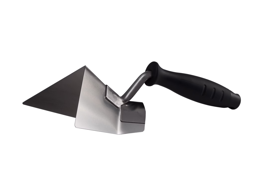 Pajarito_Dummy_Special Outside corner filler_175830_-2023-03 Gros plan d'une truelle d'angle en acier inoxydable avec un manche ergonomique en plastique noir. La lame métallique triangulaire inclinée forme un angle droit net, utilisé pour appliquer et façonner le mortier ou l'enduit dans les travaux de maçonnerie et de finition. Une tige courte et courbée relie la lame au manche antidérapant et confortable, l'outil étant présenté sur un fond blanc uni.